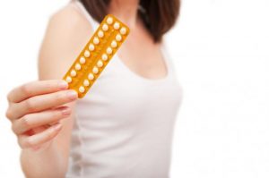 a-woman-is-holding-up-a-pack-of-contraceptive-pills